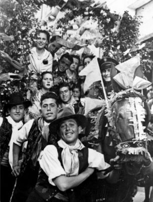 Miembro de la Peña (primer plano) con un carro adornado, en las fiestas de 1950. En aquellos años todavía no se empleaban los cucuruchos realizados con papel de seda.